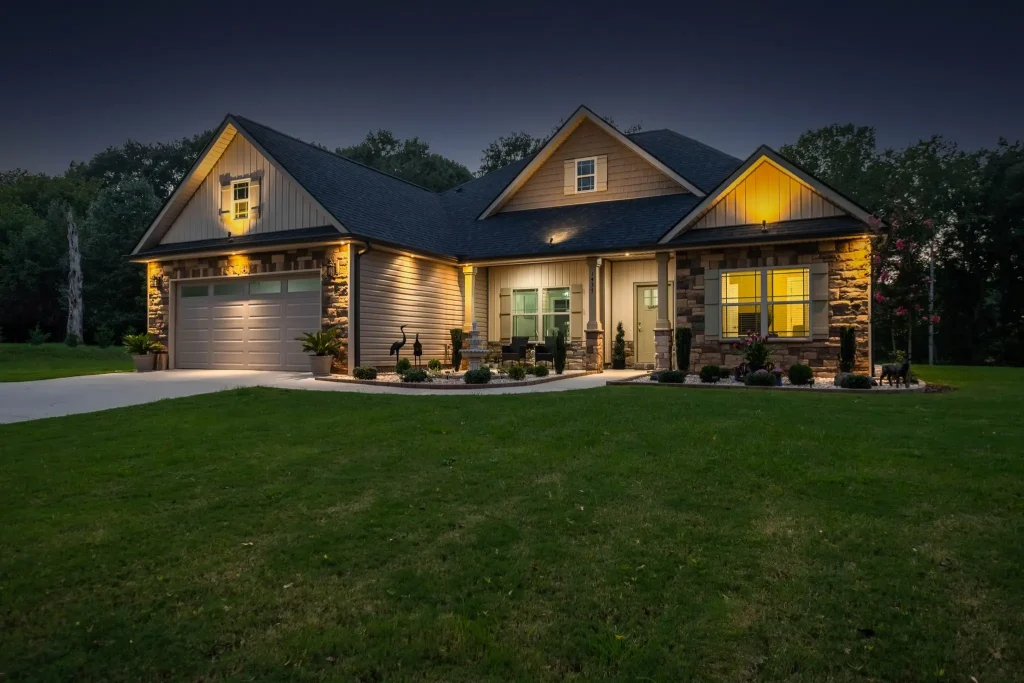 Single-story house at dusk with warm, glowing lights