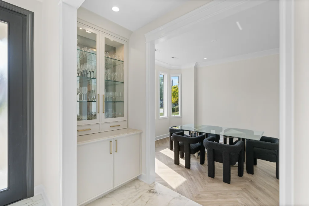 Bright dining room with a glass table and six black chairs