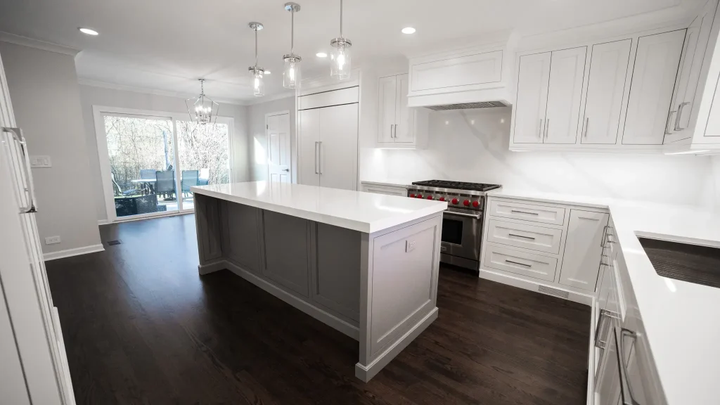 Modern kitchen with dark hardwood floors, white cabinetry, and large island
