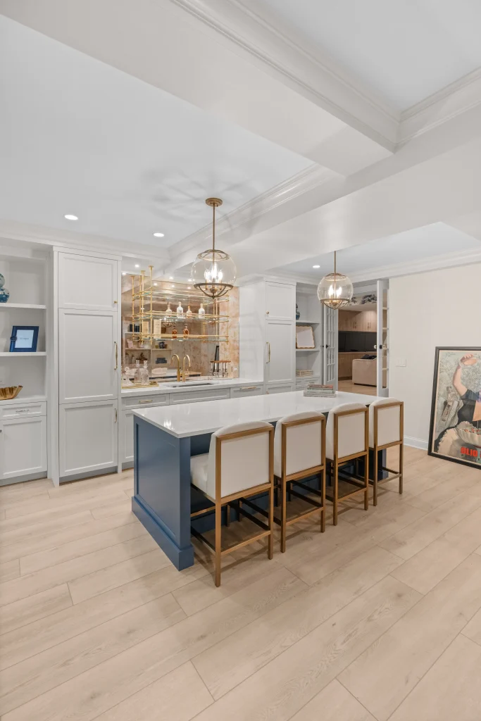 Stylish kitchen with a large island, blue base, and white countertop surrounded by four cushioned stools