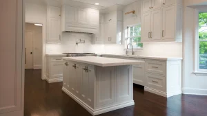 A bright, modern kitchen with white cabinetry, a central island, and stainless steel appliances