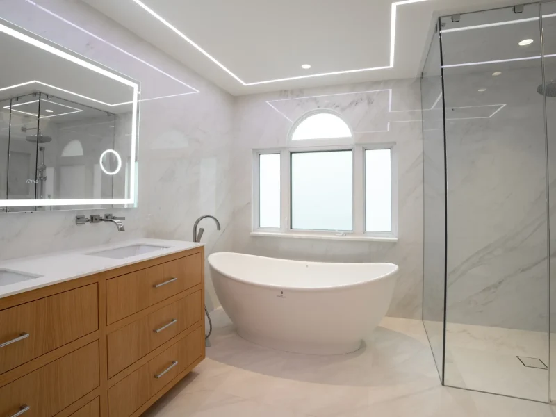 Modern bathroom with a freestanding tub, glass-enclosed shower, and double vanity