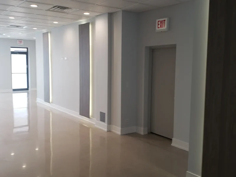 Modern hallway with polished floors, recessed lighting, and decorative wall panels