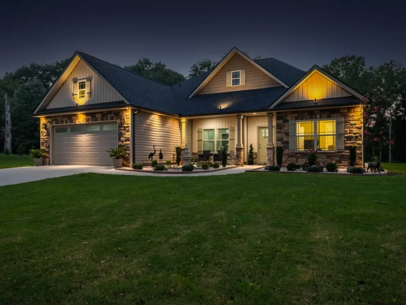 Single-story house at dusk with warm, glowing lights